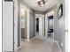 Hallway with grey walls, carpet, and three white doors leading to other rooms at 4797 Flower St, Wheat Ridge, CO 80033