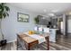 Eat-in kitchen features gray cabinets, stainless steel appliances, a breakfast bar, and hardwood floors at 4797 Flower St, Wheat Ridge, CO 80033