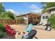 Outdoor patio area and fire pit nestled in a fenced backyard with gravel and mature trees at 1713 S Holland St, Lakewood, CO 80232