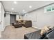 A finished basement featuring carpet floors, large sofa, ottoman, and a black leather sofa at 1713 S Holland St, Lakewood, CO 80232