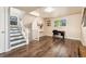 Finished basement with an office area, featuring durable flooring, natural light, and stairs to main level at 1713 S Holland St, Lakewood, CO 80232