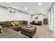 A finished basement with gray walls, carpet floors, large sofa, ottoman, and a small sofa at 1713 S Holland St, Lakewood, CO 80232