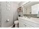 A bathroom with a white vanity, mirror, toilet, mosaic tile wall, and decorative shelving at 1713 S Holland St, Lakewood, CO 80232
