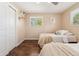 A bedroom featuring two twin beds, wood floors, ceiling fan, and white closet door at 1713 S Holland St, Lakewood, CO 80232