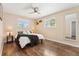 Primary bedroom featuring wood floors, natural light from two windows, and a ceiling fan at 1713 S Holland St, Lakewood, CO 80232