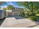Two-story home showcasing a spacious driveway and two-car garage, with mature trees and landscaping at 1713 S Holland St, Lakewood, CO 80232