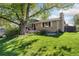 Well-maintained home with a brick exterior, a large tree in the yard, and a cozy front patio area at 1713 S Holland St, Lakewood, CO 80232