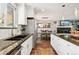 Kitchen with granite counters, stainless appliances, and breakfast bar leading to dining area and living room with fireplace at 1713 S Holland St, Lakewood, CO 80232