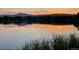 Beautiful lake view at sunset; serene waters reflect soft sunlight and distant mountains at 1713 S Holland St, Lakewood, CO 80232