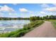 Scenic view of lakeside path with trees, tranquil lake, and mountain backdrop at 1713 S Holland St, Lakewood, CO 80232