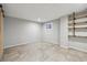 Unfinished basement with tile flooring, a small window, and built-in shelving at 1811 S Quebec Way # 60, Denver, CO 80231