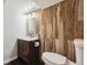 Charming bathroom featuring a wood accent wall, modern vanity, and toilet at 1811 S Quebec Way # 60, Denver, CO 80231
