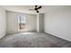 Spacious primary bedroom with large window, neutral paint, and plush gray carpeting at 1811 S Quebec Way # 60, Denver, CO 80231