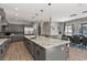 Expansive kitchen with gray cabinets, large island with seating, and views into the dining area at 3422 W 155Th Ave, Broomfield, CO 80023