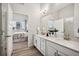 Bright bathroom showcasing double sinks with quartz countertops and a view into the bedroom at 485 Interlocken Blvd # 106, Broomfield, CO 80021