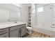 Stylish bathroom with gray vanity, white countertop, shower with tub and tiled wall at 485 Interlocken Blvd # 106, Broomfield, CO 80021
