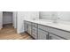 Bright bathroom featuring double vanity with gray cabinets, quartz countertop, and wood-look flooring at 485 Interlocken Blvd # 106, Broomfield, CO 80021