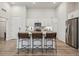 Modern kitchen featuring an island with seating, stainless steel appliances, and bright, neutral colors at 485 Interlocken Blvd # 106, Broomfield, CO 80021
