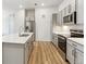 Bright kitchen features stainless steel appliances, gray cabinets, quartz countertops, and wood flooring at 485 Interlocken Blvd # 106, Broomfield, CO 80021