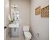 Stylish powder room featuring a wall-mounted sink, modern fixtures, and decorative wall art, maximizing a small space at 2326 Eliot St # 7, Denver, CO 80211