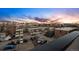 An aerial view shows townhomes with parking and a city skyline at sunset at 2326 Eliot St # 7, Denver, CO 80211