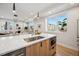 Modern kitchen featuring an island with sink, white countertops, and bright natural light from the window at 2326 Eliot St # 7, Denver, CO 80211