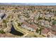 Beautiful aerial view of a neighborhood with walking trails, a pond, and snow-capped mountains in the distance at 6024 W Colorado Ln, Lakewood, CO 80232