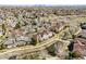 Aerial view of neighborhood featuring residential homes, lush trees, and community ponds at 6024 W Colorado Ln, Lakewood, CO 80232