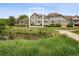 Back of the unit overlooking a tranquil pond, with a patio and well-maintained landscaping at 6024 W Colorado Ln, Lakewood, CO 80232