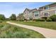 Exterior view of the home with a well-maintained lawn, mature trees, and manicured landscaping at 6024 W Colorado Ln, Lakewood, CO 80232