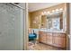 Well-lit bathroom featuring double sinks, a glass-enclosed shower, and modern fixtures at 6024 W Colorado Ln, Lakewood, CO 80232