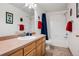Bright bathroom featuring a vanity with sink, shower-tub combo and patriotic decorations at 6024 W Colorado Ln, Lakewood, CO 80232