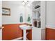 Charming half-bath with pedestal sink, decorative mirror and cabinet for organized storage at 6024 W Colorado Ln, Lakewood, CO 80232