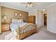 Cozy bedroom featuring a wooden bed, ceiling fan, and en-suite bathroom access at 6024 W Colorado Ln, Lakewood, CO 80232