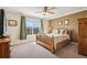 Comfortable bedroom featuring neutral carpets, a ceiling fan, and a large window at 6024 W Colorado Ln, Lakewood, CO 80232