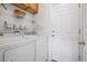 Convenient laundry room with modern washer and dryer, shelving, and ample storage space at 6024 W Colorado Ln, Lakewood, CO 80232