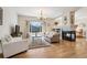 Inviting living room features hardwood floors, a cozy fireplace, and large windows with views of the community at 6024 W Colorado Ln, Lakewood, CO 80232