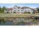 Exterior view of the townhouse, with a patio or deck overlooking a serene pond at 6024 W Colorado Ln, Lakewood, CO 80232