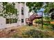 This backyard features a wooden deck with stairs, grass and mature trees at 9371 Princeton Ln, Highlands Ranch, CO 80130