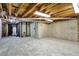 Unfinished basement with concrete walls and floor, offering ample storage space at 9371 Princeton Ln, Highlands Ranch, CO 80130