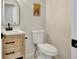Charming powder room with light wood vanity, unique mirror, and neutral colored walls at 9371 Princeton Ln, Highlands Ranch, CO 80130