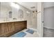 Modern bathroom features a wood vanity with dual sinks and a luxurious walk-in shower with gold fixtures at 9371 Princeton Ln, Highlands Ranch, CO 80130