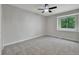 Bright bedroom showcases a large window overlooking trees, new carpet, and modern ceiling fan at 9371 Princeton Ln, Highlands Ranch, CO 80130