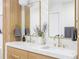 Bathroom featuring double sinks, marble counters, and wood cabinets at 1 Winged Foot Way, Littleton, CO 80123