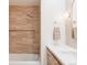 Bright bathroom features a shower over bath, inset shelving, and modern vanity with marble countertop at 1 Winged Foot Way, Littleton, CO 80123