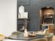 Dining area with a dark table, upholstered chairs, wet bar, and painted brick fireplace in the background at 1 Winged Foot Way, Littleton, CO 80123