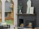 Close-up of painted brick fireplace with a wood-burning insert, decor, and a view of the yard at 1 Winged Foot Way, Littleton, CO 80123