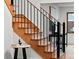 Elegant wooden staircase with black wrought iron railing and a table with decor alongside it at 1 Winged Foot Way, Littleton, CO 80123