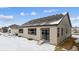 Tan house exterior with dark trim, sliding glass doors, and snow-covered yard at 16850 Mckay Dr, Mead, CO 80542