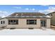 Rear view of a tan house with dark trim, sliding glass doors, and a snow-covered yard at 16850 Mckay Dr, Mead, CO 80542